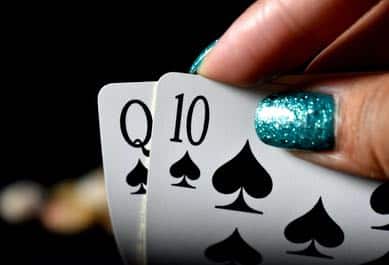 Nybörjare i poker kikar på hålkorten spader dam och spader tio