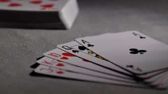 En pokerhand med fem kort som ligger på ett bord.